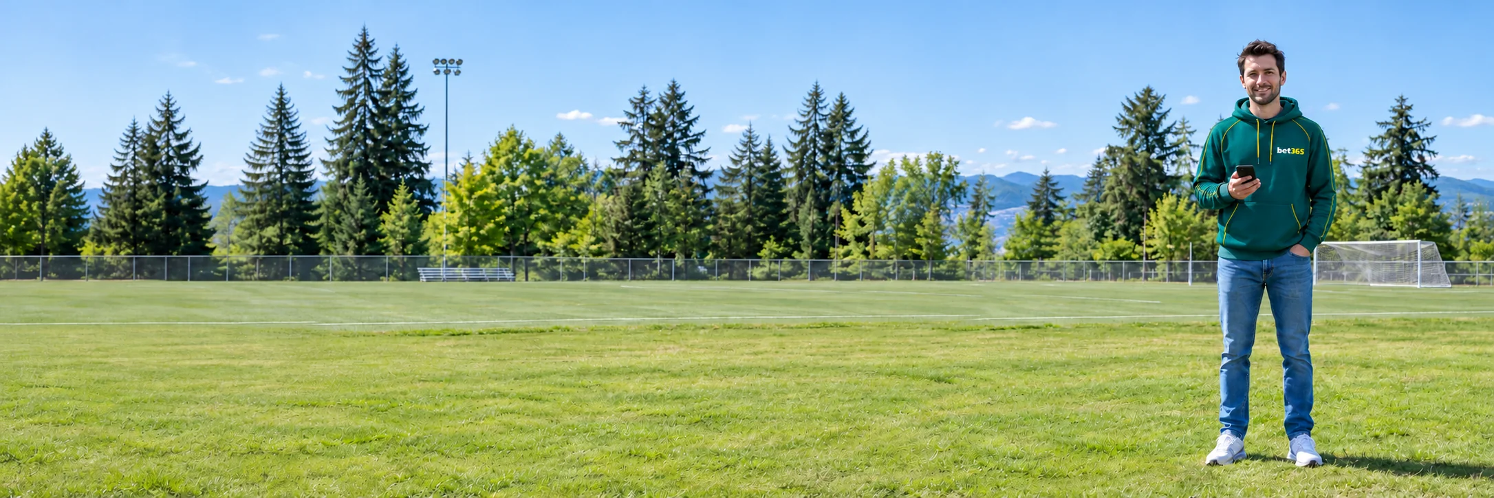 Fictional adult using a smartphone beside a Canadian sports field in bet365 colours